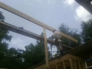 Carpenter setting a ridge beam over a new addition frame — Ice Dam Removal by Roofing Brothers in Bronxville