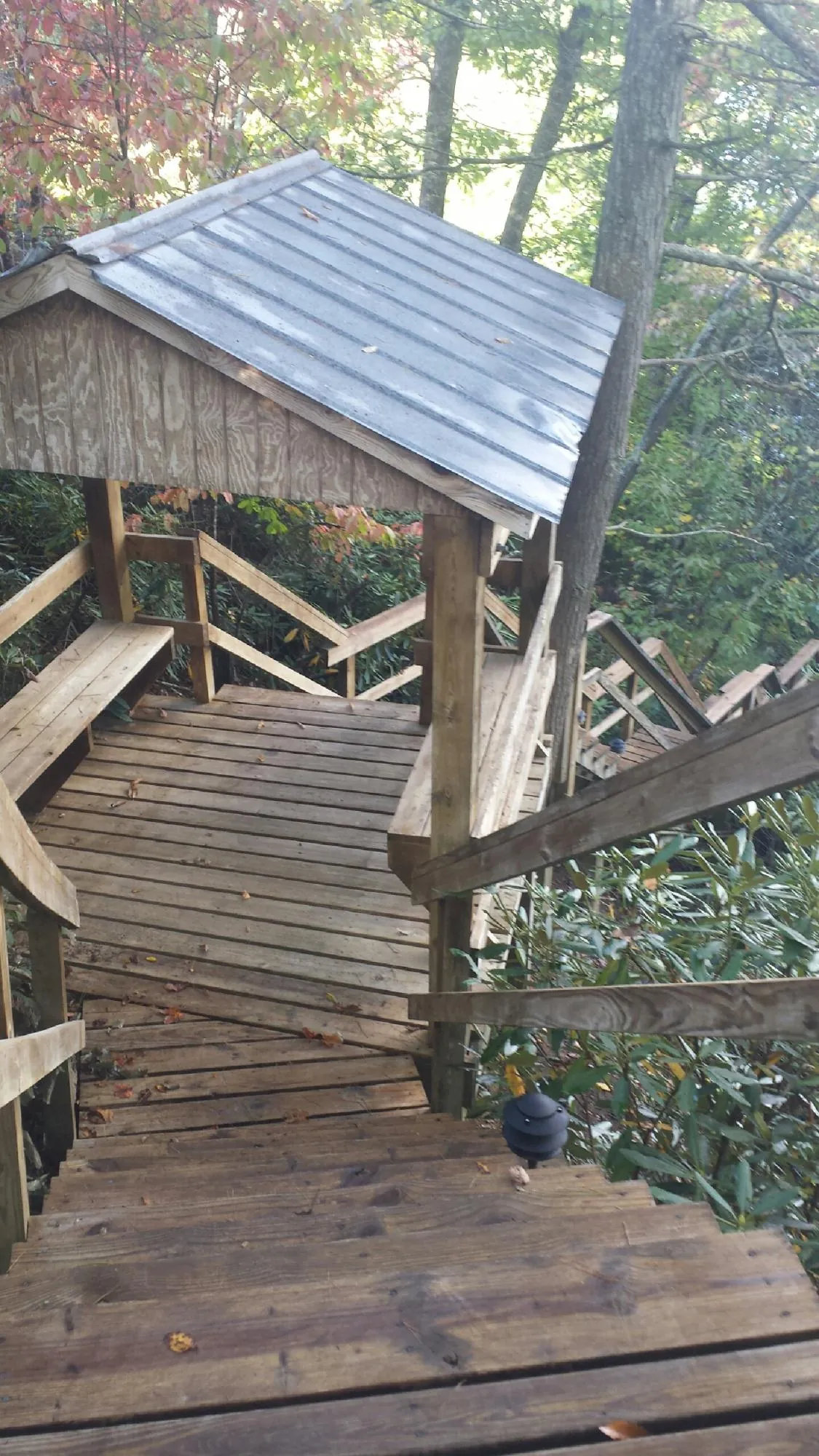 Metal roofed shelter over wooden steps on a wooded walkway — Skylight Repair & Installation work by our crew in Bronxville