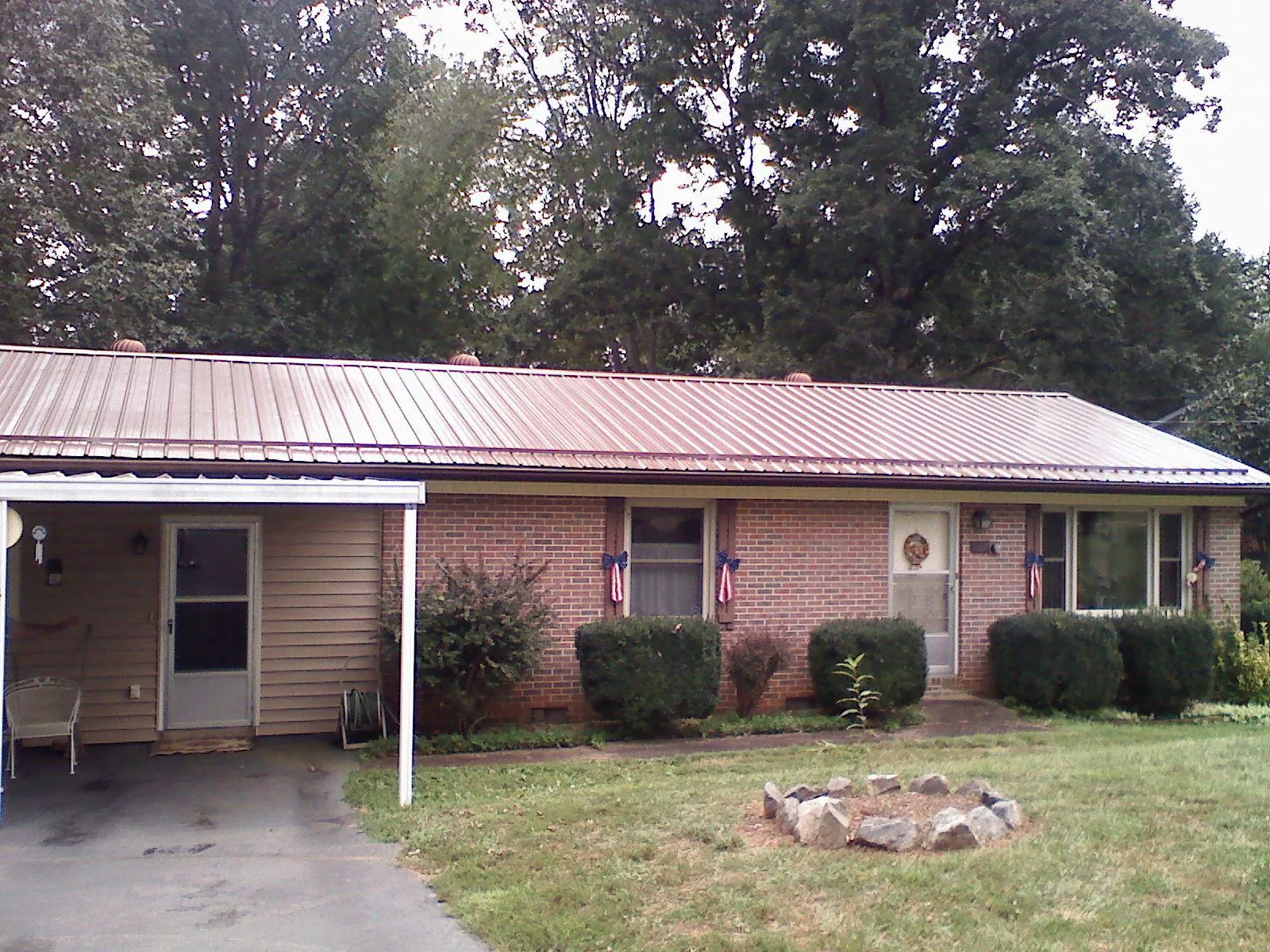 Bronze metal roof and carport on a brick ranch home — Roof Repair work by our crew in Bronxville